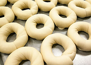 Bagelteiglinge liegen auf einem Backblech.