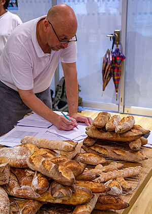 An einem mit Baguettes bereits gut gefülltem Tisch entwickelt Schelli ein Rezept zum Experimentieren für den Baguette-Kurs. 