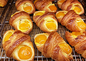 In der Auslage einer Bäckerei liegen Plunderteilchen mit Aprikosen.