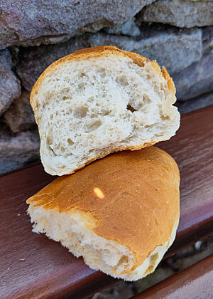 Ein aufgerissenes Brötchen mit wattiger, heller Krume.