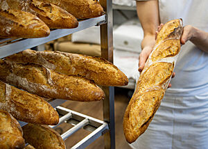 Mehrere Baguettes liegen zum Abkühlen in einem Regal.
