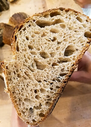 Das angeschnittene Landbrot zeigt seine grobe, unregelmäßige Porung.