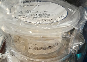 Im Regal eines Hobbybäcker-Ladens liegt Frischhefe in Plastikdosen aus.