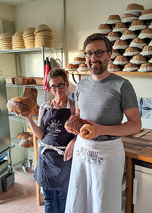 Angela Nöthlings hält ein Bloomer, Lutz Geißler ein Schwarzbrot und einen Bagel in der Hand.