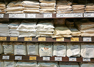 Eine große Auswahl an unterschiedliche Mehlsorten liegt in den Regalen eines Hobbybäckerladens.