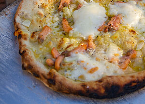 Im Holzofen gebackene Lachs-Pizza mit Olivenöl und Mozzarella.