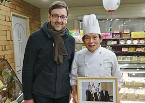 Lutz Geißler steht neben einem Baumkuchenbäcker in seiner Konditorei.