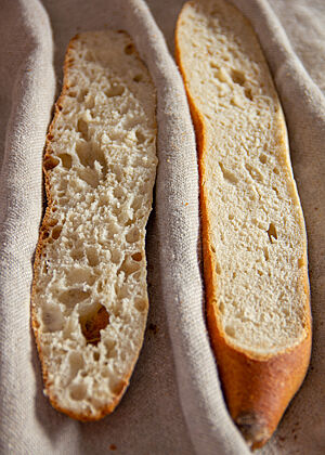 Das, was die Fotos der Baguettes im nicht angeschnittenen Zustand bereits vermuten ließen, wird nun bei den Baguettes im Anschnitt sichtbar. Das Baguette von Lafer ist deutlich feinporiger und kleinvolumiger als der Entwurf von Lutz Geißler. Dieser ist etwas größer im Volumen und hat eine unregelmäßige, mittlere bis grobe Porung. 
