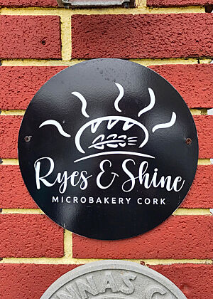 Schild mit der Aufschrift „Rye's & Shine Microbakery Cork“.