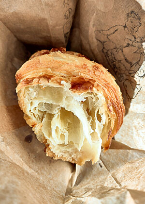 Ein aufgerissenes Croissant mit grober Wabenstruktur im Inneren.