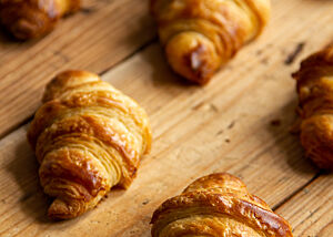 Fertig gebackene Croissants die aus der einmal gewalzten Teigplatte von Hand weiter verarbeitet und geformt wurden.