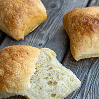 Ein aufgeschnittenes Ciabattini zeigt die helle, mittelporige und sehr locker, fluffige Krume. 