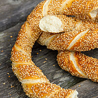 Ein auseinandergebrochener Simit zeigt die weiche, lockere Krume umgeben von der dünnen, knusprigen Kruste.