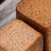 Roggenschrotbrot (links) und Pumpernickel (rechts) haben eine feinporige, dichte Krume.