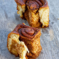 Zwei abgeteilte Kanelboller offenbaren den Zimt in der langfaserigen Krume.