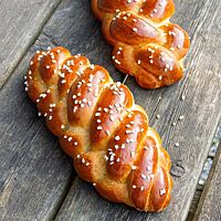 Zwei Hefezöpfe, aus vier und fünf Strängen geflochten, sind goldbraun ausgebacken und mit Hagelzucker bestreut.