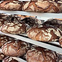 Ein Brotwagen voll bestückt mit rustikalen Roggenbroten.