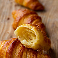 Das aufgebrochene Croissant eröffnet den Blick auf die feinblätterige, wattig, fluffige Krumenstruktur des Blätterteiges.  