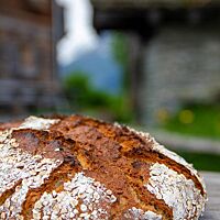Die kräftig ausgebackene Dinkel-Hafer-Kruste ist mit weißem Mehl und Haferflocken bestreut.