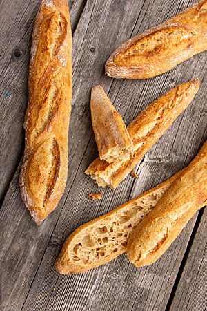 Im Anschnitt wird die ungleichmäßig grobporige Krume der Dinkelbaguettes sichtbar.