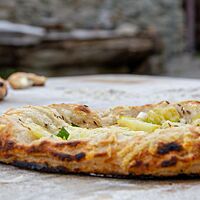 Der dicke Rand der flachen Dinnete ist knusprig ausgebacken und zeigt appetitliche Brandspuren.