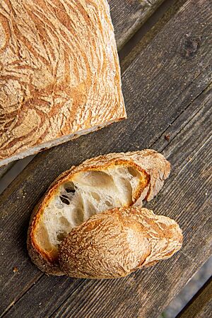 Das Ciabatta im Anschnitt zeigt die grobe Porung der hellen Krume und die dicke, knusprige Kruste.