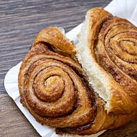 Das auseinandergebrochene Franzbrötchen zeigt die weiche, helle Krume.