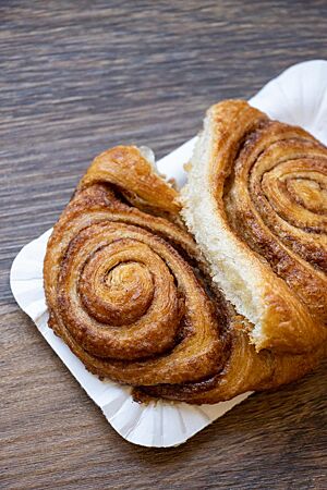 Das auseinandergebrochene Franzbrötchen zeigt die weiche, helle Krume.