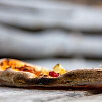 Der Rand der Pizza ist stellenweise sehr dunkel ausgebacken.