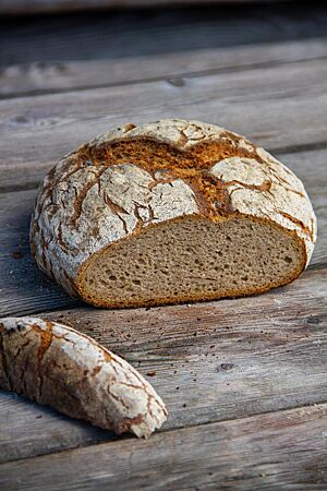 Das angeschnittene Kalchkendlbrot zeigt seine lockere, kleinporige Krume umhüllt von der knusprigen, rustikal aufgerissenen Kruste.