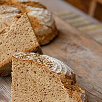 Das ohne Dampf gebackene Kärntner Bauernbrot hat eine kleinporige, lockere Krume und eine rustikal aufgerissene, bemehlte Kruste.