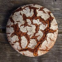 Die kräftige Kruste des Roggenbrotes ist von vielen Rissen durchzogen.