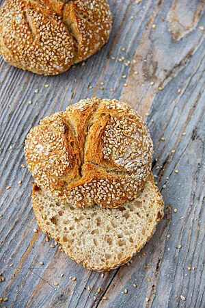 Beim aufgeschnittenen Sesambrötchen kommt die mittelporige, elastische Krume zum Vorschein.