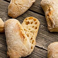 Ein aufgeschnittenes Brötchen zeigt die lockere, elastische Krume umgeben von der hell ausgebackenen Kruste.