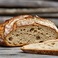 Im Anschnitt zeigt das Weizenmischbrot mit Hirse die lockere, offenporige Krume.