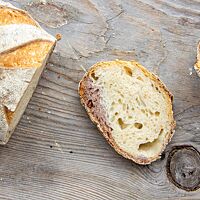 Die Scheibe eines besonderen Weizensauerteigbrotes zeigt die Mischung aus heller Krume ohne Walnüsse und dunkler Krume mit Walnusstrester.