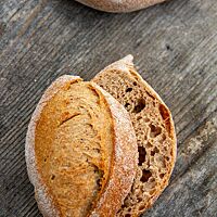 Der Einblick in das aufgeschnittene Weizenvollkornbrötchen zeigt die braune Krume umgeben von der kräftig ausgebackenen Kruste.