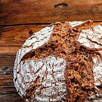 Die kräftige Kruste des Vollkornbrotes ist bemehlt und rustikal aufgerissen.