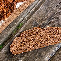 Eine Scheibe des Vollkornbrotes zeigt die dunkelbraune Krume.