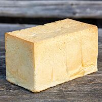 Das im Kasten mit Deckel gebackene Shokupan hat an allen Seiten eine sehr helle, dünne Kruste eine glatte, gerade Oberfläche.