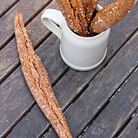 Die mit Kümmel und grobem Salz bestreuten, spitz zulaufenden, dünnen Stangen sind der Länge nach mittig aufgerissen.