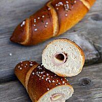 Angeschnitten zeigen die mit gekochtem Schinken und Käse gefüllten Almstangerl ihre feinporige, lockere Krumenstruktur.