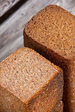 Roggenschrotbrot (links) und Pumpernickel (rechts) haben eine feinporige, dichte Krume.