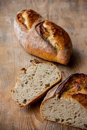 Im Anschnitt wird die wilde Porung und elastische Krume des kräftig ausgebackenen und rustikal aufgerissenen Bâtard gut sichtbar.