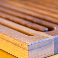 Zum Auffangen der Krümel sind in das Holz des Schneidebrettes Rillen in Schlangenlinien eingearbeitet.
