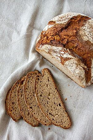Das in mehrere Scheiben geschnittene Erdmandelbrot zeigt die braune Krume und die knusprige, dicke Kruste.