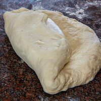 Das untere Ende des Teiglings wird über den Camembert gelegt.
