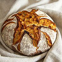 Das rustikale Bauernbrot ist kross ausgebacken und hat eine rustikal aufgerissene Kruste.