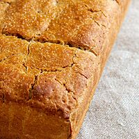 Das Roggentoastbrot aus dem ersten Backversuch hat einen flachen Laib und eine glatte Oberfläche.