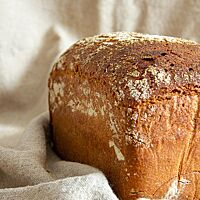 Das fertig ausgebackene Roggentoastbrot liegt auf einem Leinentuch.